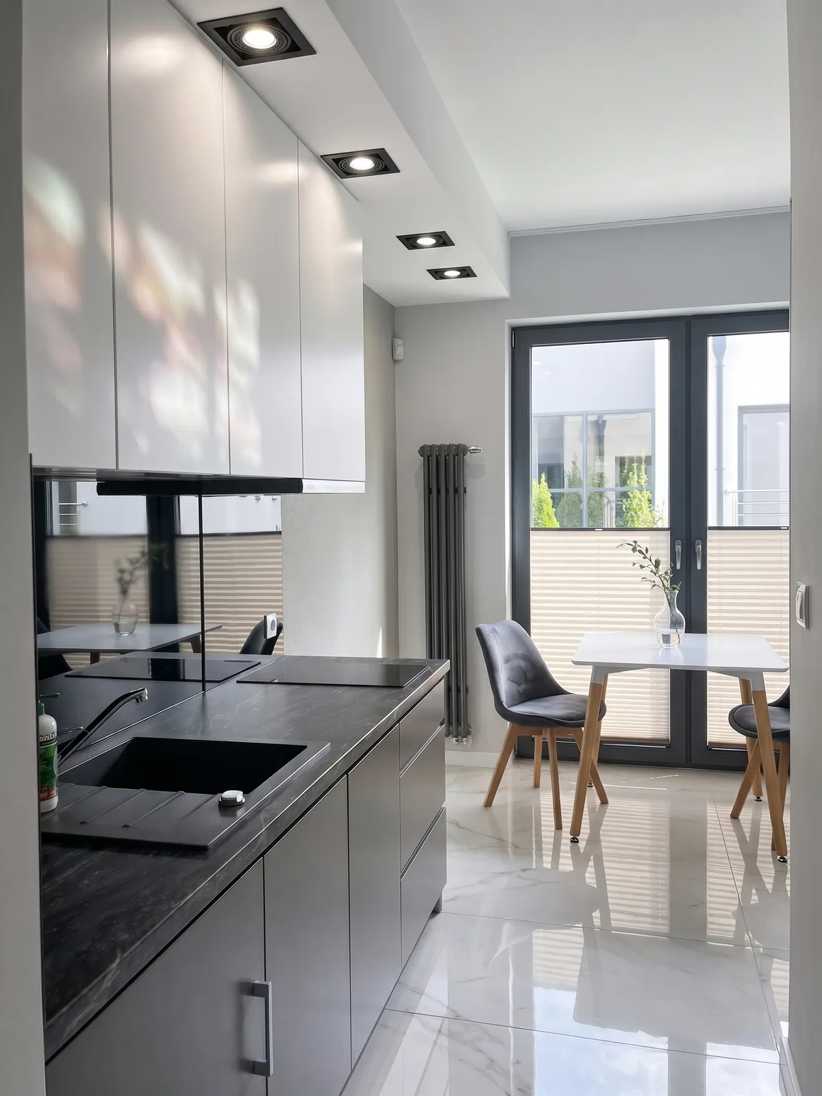 Apartamenty Szmaragdowa 10 — aneks kuchenny z płytą, jadalnią i wyjściem na balkon