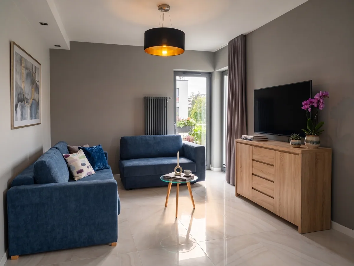 Apartamenty Szmaragdowa 10 — salon z dwiema sofami, TV i wyjściem na balkon