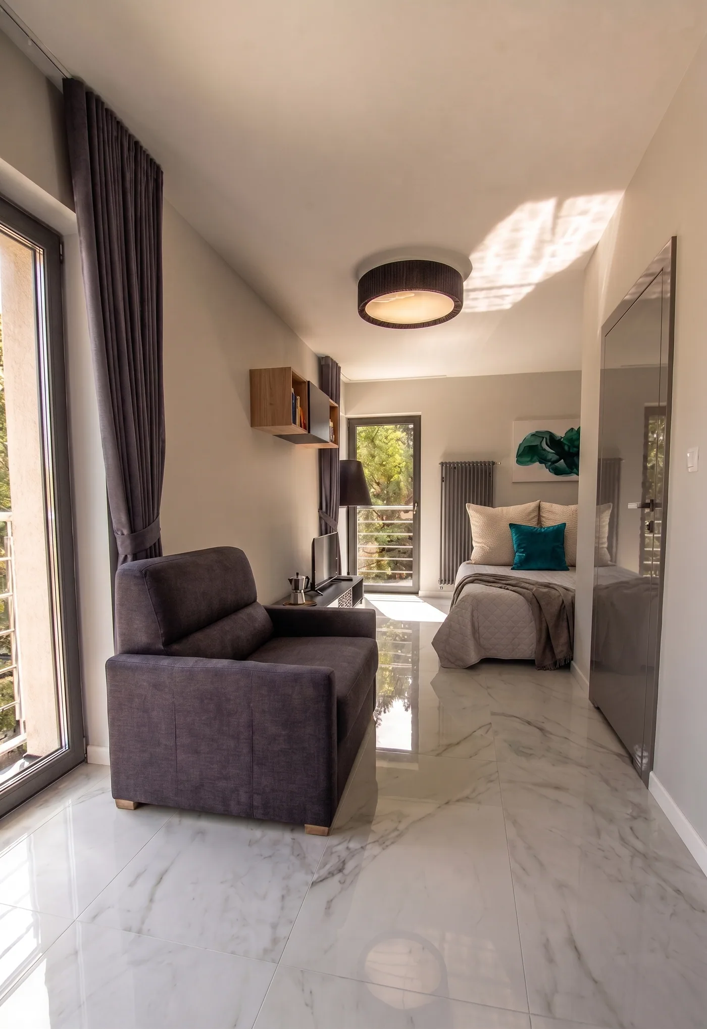 Apartamenty Szmaragdowa 10 — przestronny apartament z fotelem, sypialnią i wyjściem na balkon