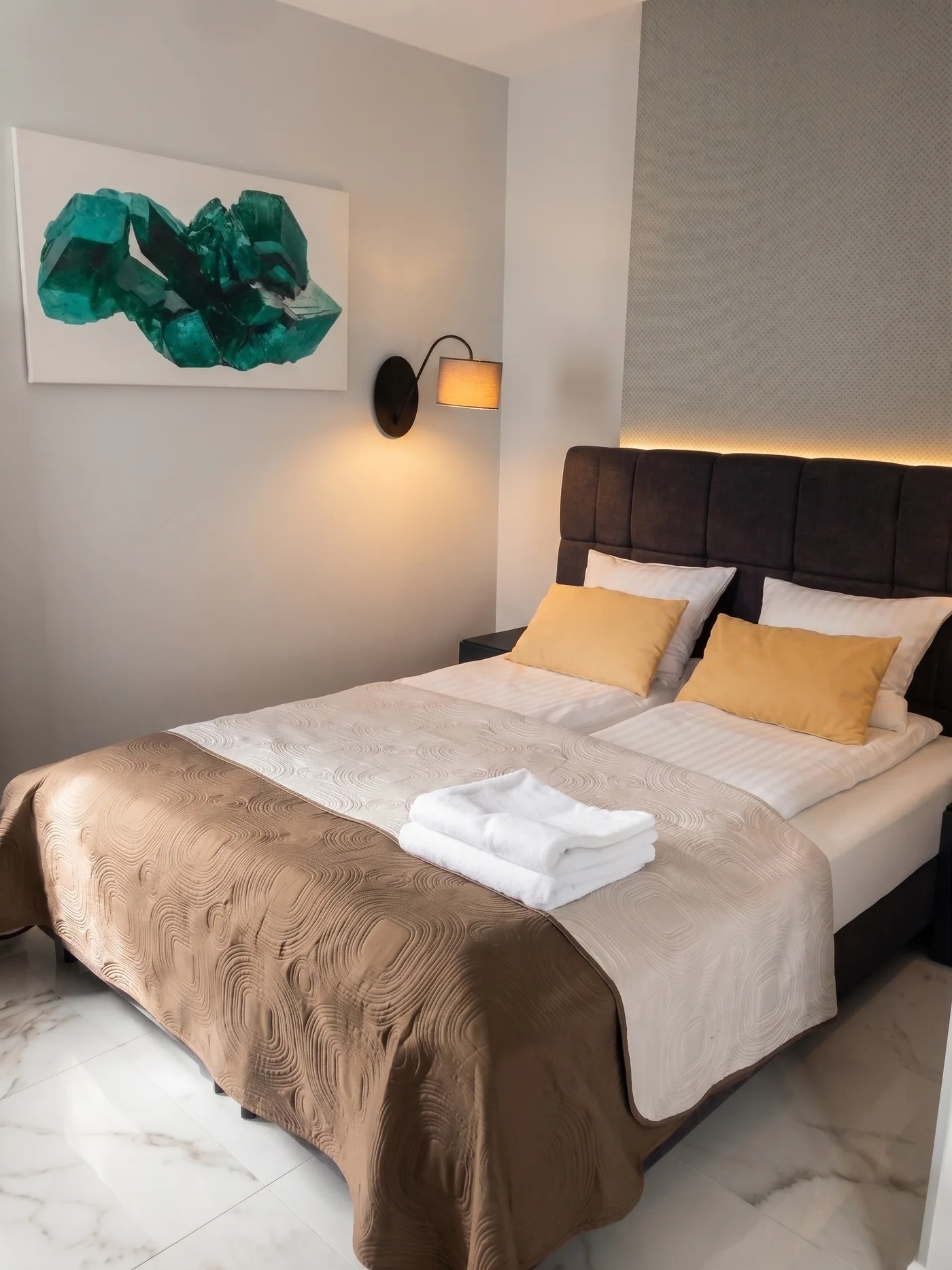 Apartamenty Szmaragdowa 10 — elegancka sypialnia z dużym łóżkiem i grafiką szmaragdu
