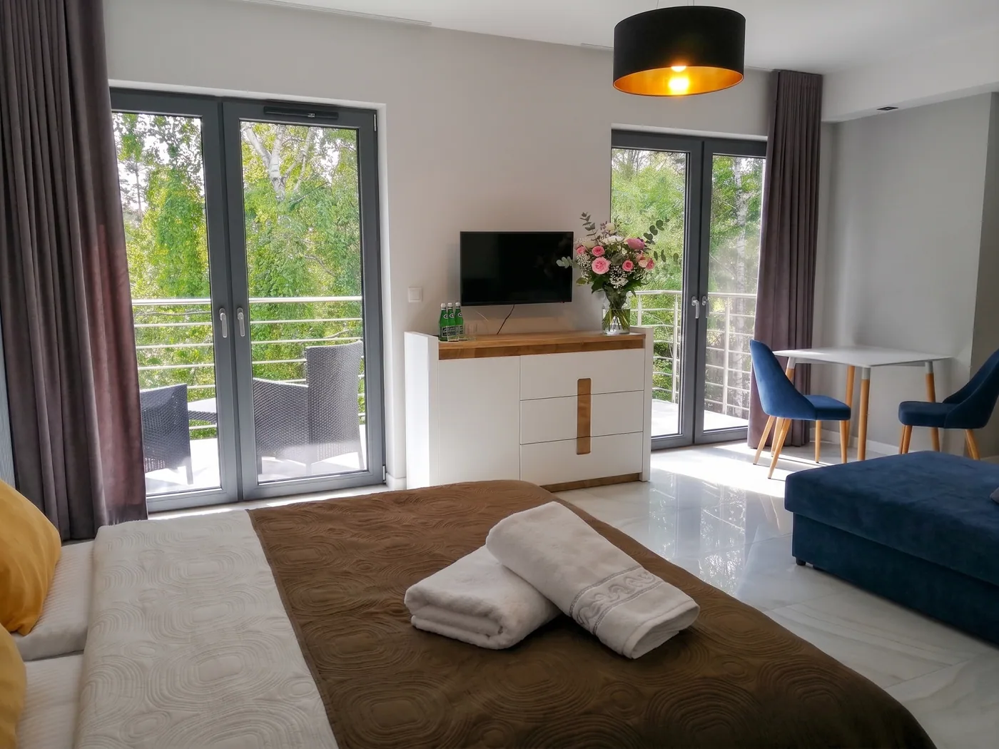 Apartamenty Szmaragdowa 10 — jasna sypialnia z TV, komodą i wyjściem na balkon